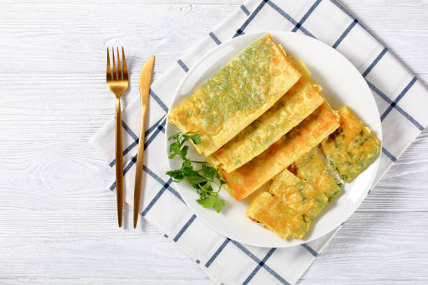 istock crispy fried thin burritos with melted cheese and greens filings on a white plate on a white wooden table, horizontal view from above, flat lay, free space, close-up 1353656236