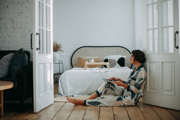 istock Young girl sitting on bed with laptop 1353658691