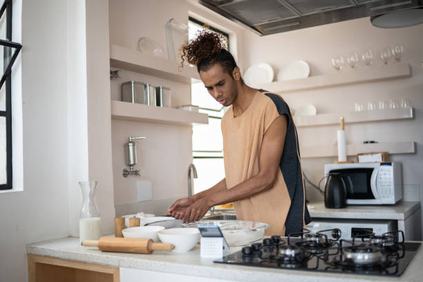 istock Young man preparing food and checking recipe on smartphone at home 1353661493