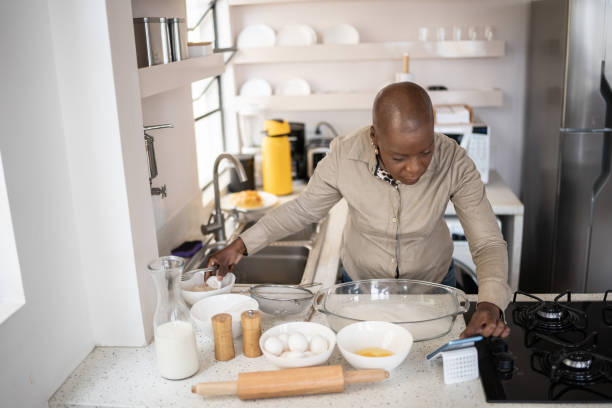istock Mature woman preparing food and checking recipe or video tutorial on smartphone at home 1353662235