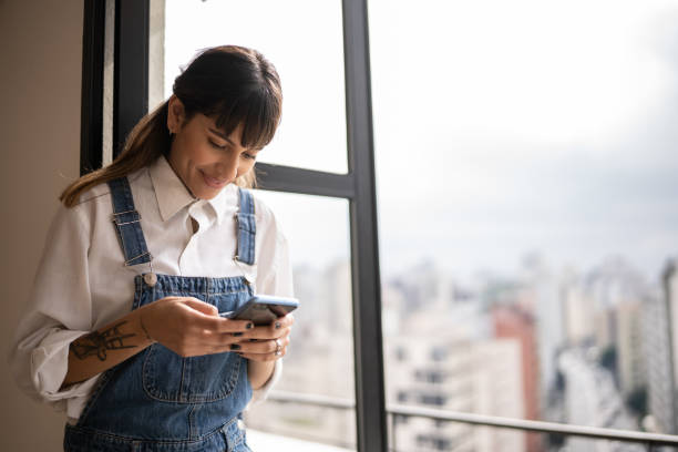 istock Young woman using the mobile phone at home 1353662355