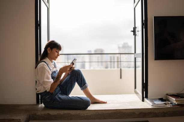 istock Young woman using the mobile phone at home 1353662433