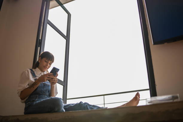 istock Young woman using the mobile phone at home 1353662447