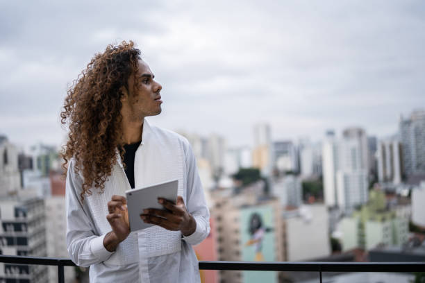 istock Contemplative young man holding a digital tablet on a rooftop 1353662926