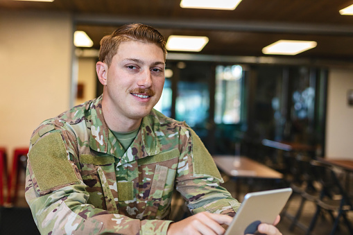 In Western Colorado Professional Working Caucasian Male National Guard Officer in Office Setting Using  Computer and Digital Tablet Technology Photo Series (Shot with Canon 5DS 50.6mp photos professionally retouched - Lightroom / Photoshop - original size 5792 x 8688 downsampled as needed for clarity and select focus used for dramatic effect)