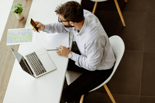 istock Businessman With Smartphone in the Office 1353668401