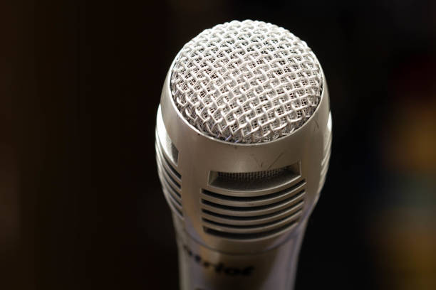 istock Professional microphone in a music studio on a black background. Record sounds and songs. Chrome metal microphone. Digital recorder and technology. Musical equipment. Close-up 1353669247