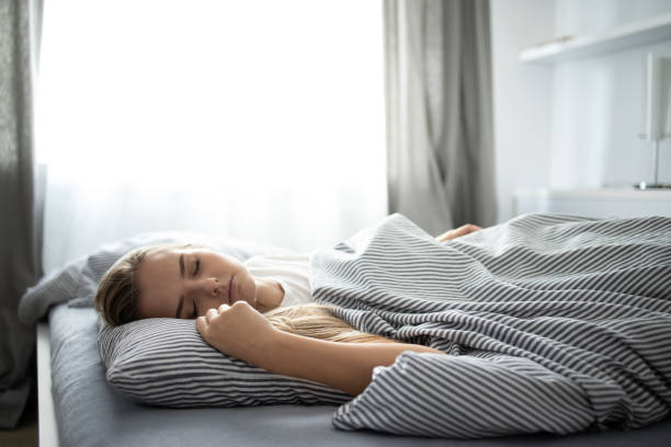 istock Pretty, young woman sleeping in her bed 1353675547