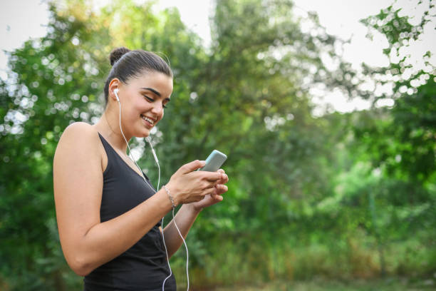 istock Workout Motivation Playlist For Cute Female During Outdoor Training Session 1353678912