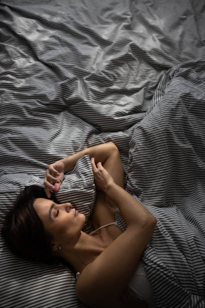 Pretty, young woman in her bed, fast asleep stock photo
