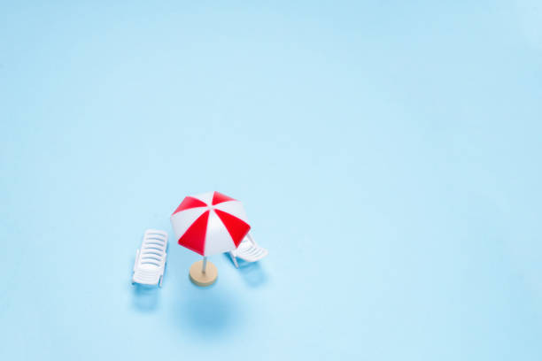 istock Travel concept. Sun lounger, red umbrella on a blue background. 1353681069