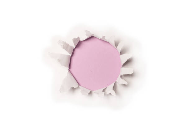 istock A hole in a white paper on a purple background. 1353681110