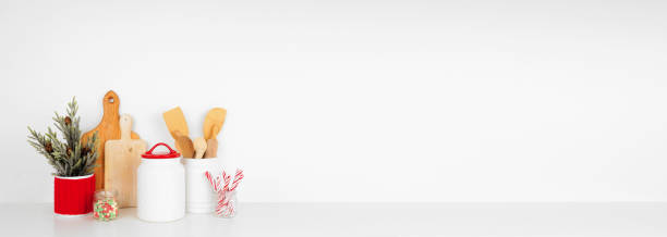 istock Christmas kitchenware, decor and sweets on a white shelf against a white wall background 1353681857