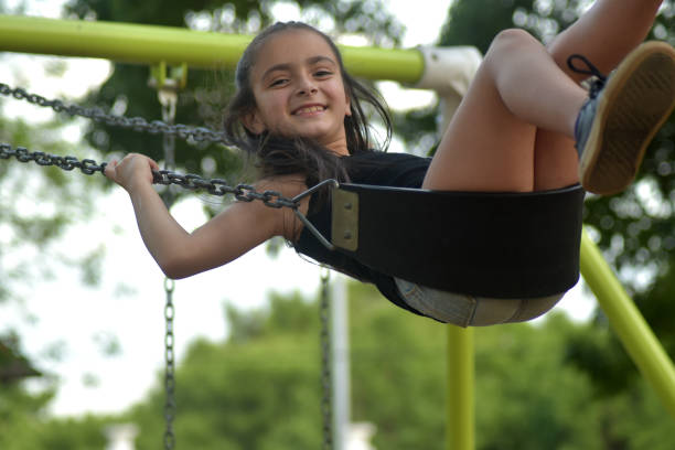 istock girl playing on the swing 1353684384