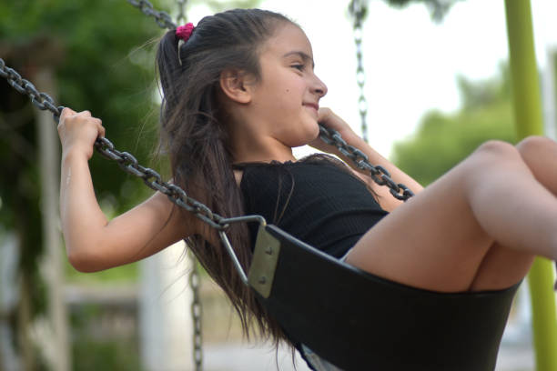 istock girl playing on the swing 1353684666