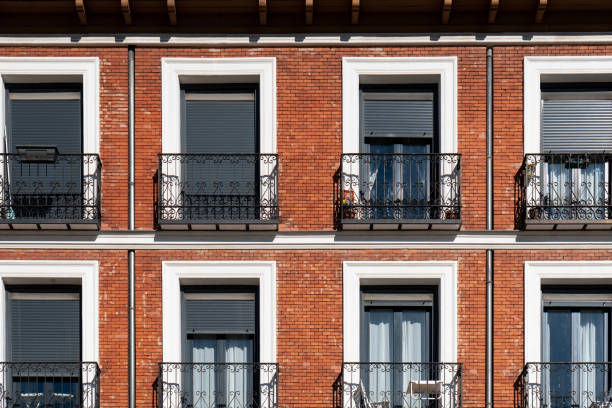 istock Orange brick facade with wrought iron balconies 1353686307