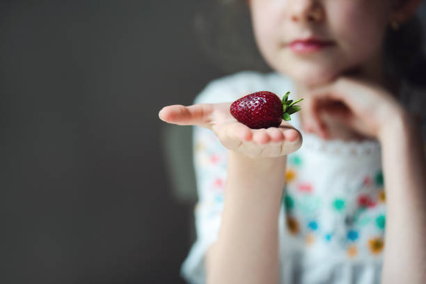 Young girl with a strawberry, close up