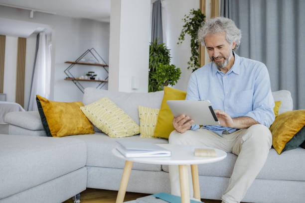 istock A senior man uses a digital tablet at home 1353689286