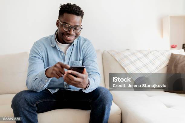 Cheerful Black Man Using Mobile Wearing Eyeglasses Texting And Browsing Internet Stock Photo - Download Image Now