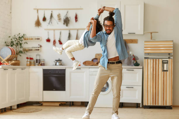 istock Dad spinning his son in the air while playing together and having fun at home 1353694151
