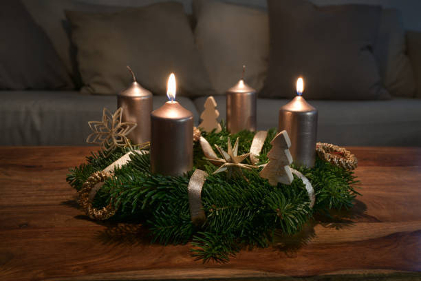 zwei goldene kerzen werden für den zweiten sonntag auf einem adventskranz mit natürlicher weihnachtsdekoration auf einem hölzernen couchtisch, kopierraum, ausgewähltem fokus angezündet - adventskranz stock-fotos und bilder