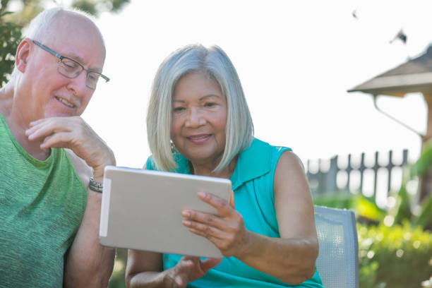istock Senior Man and Woman looking at digital tablet together 1353699705