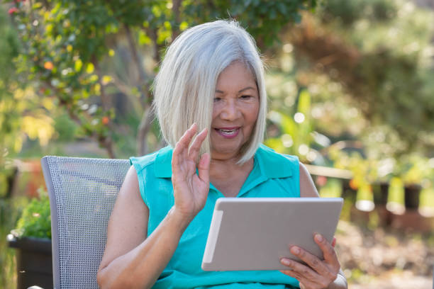 istock Senior Woman using digital tablet outdoors to call family 1353699713