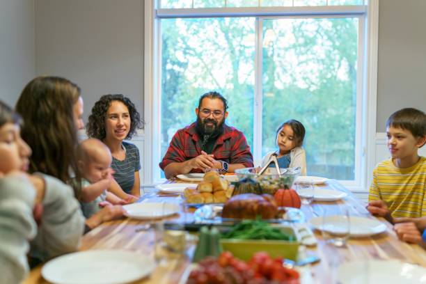 multiethnische gruppe von familie und freunden feiert gemeinsam thanksgiving - domestic life mother baby multi ethnic group stock-fotos und bilder