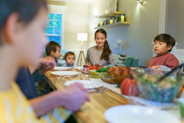 istock Family praying before holiday dinner 1353700272