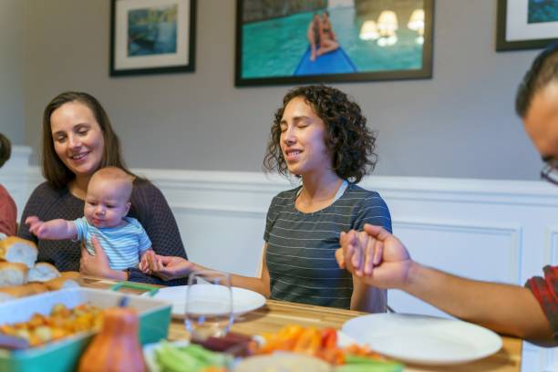istock Family praying before holiday dinner 1353700277