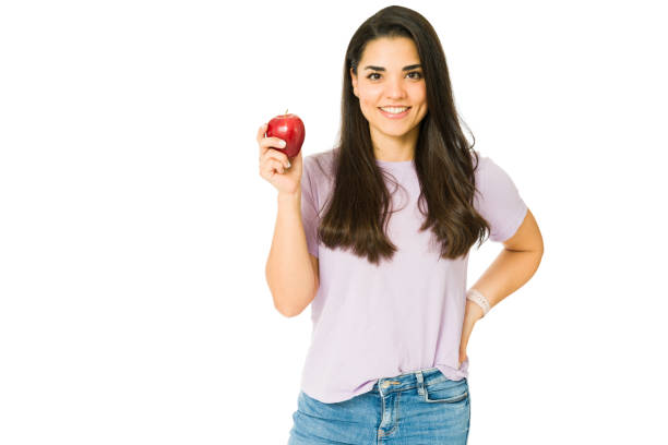 istock Young woman showing a red apple 1353704906