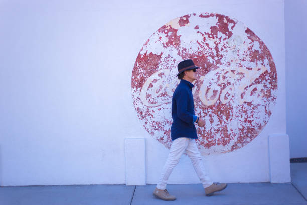 Marfa, TX: A pedestrian walking past a vintage Coke ad in downtown Marfa.