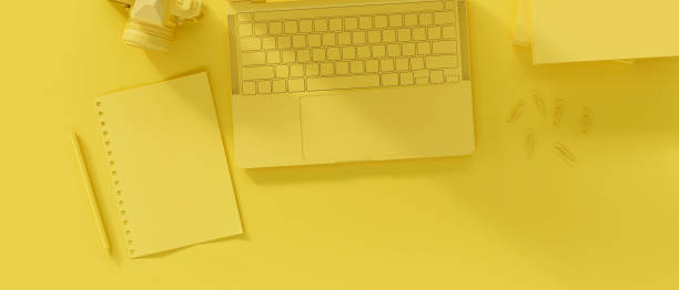 istock Yellow workplace with laptop computer and stationery. monochrome. Top view 1353716802