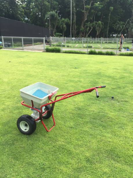 istock Push fertilizer machine over a large green garden. 1353728167