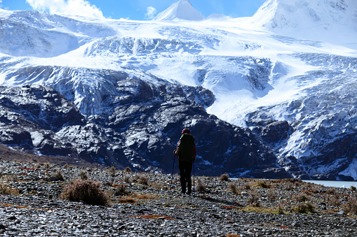 Woman backpacker hiking in winter high altitude mountains