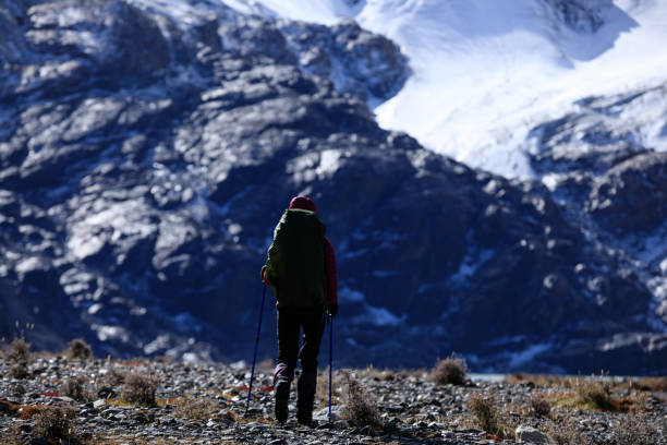 istock Woman backpacker hiking in winter high altitude mountains 1353728721