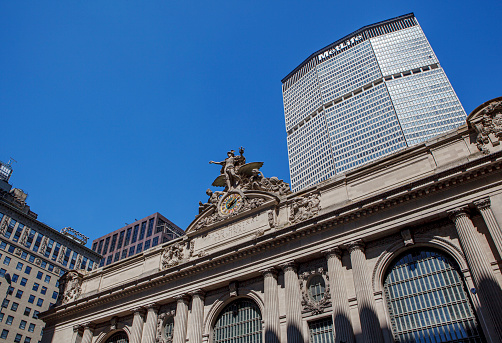 New York City, USA - September 9, 2011: Low angle view of Sculptures and Tiffany clock on the outer facade of Grand Central Station, with the MetLife Building on the background. No people. Daylight shot