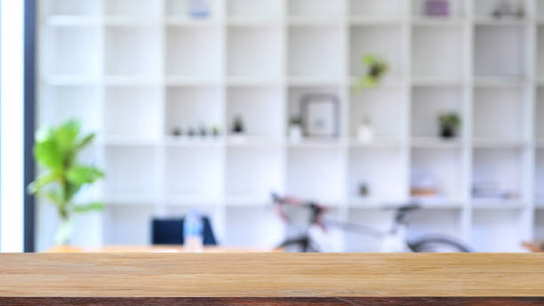 istock Wood table with blurred bookshelf in background. For montage product display. 1353729691