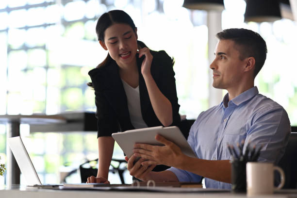 istock Handsome businessman discussing business plan with his colleague. 1353729775
