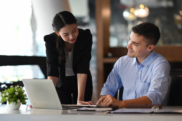 istock Smiling businessman explaining information to his colleagues. 1353729776