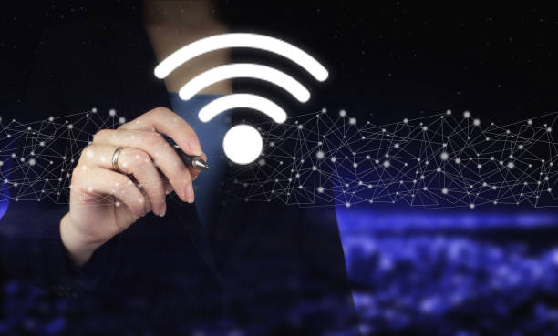 istock Business networking connection concept. Hand holding digital graphic pen and drawing digital hologram Wi Fi sign on city dark blurred background. Wi Fi wireless concept. 1353730729