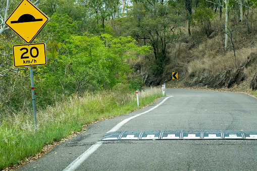 Speed bumps on mountain road warning sign and speed should be 20 km per hour over them