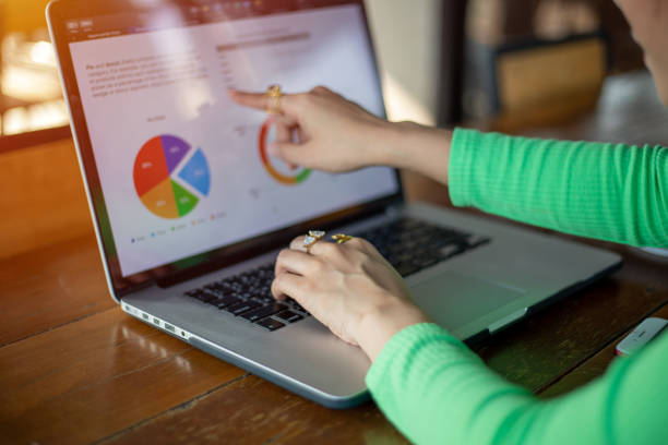 istock Asian businesswomen using notebook for analysis documents and graph financial diagram working 1353735638