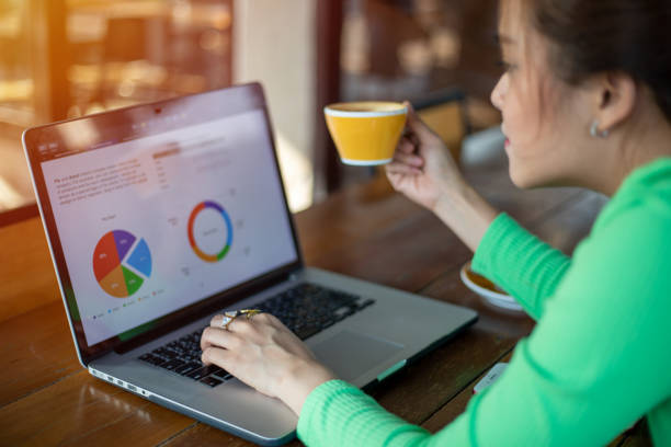 istock Asian businesswomen using notebook for analysis documents and graph financial diagram working 1353736241
