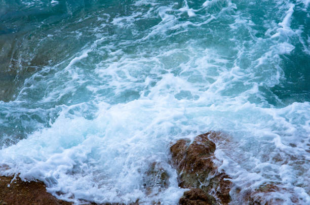 istock Waves crushing into the rocks. Bubble sea waves hit the rocks. (Koh Lipe, Thailand) 1353736612