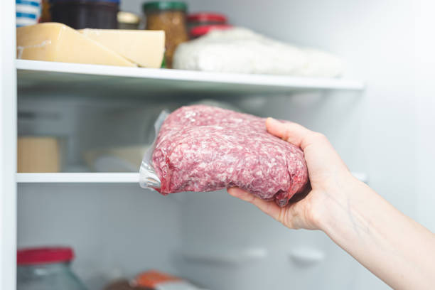 istock the girl gets the minced meat from the refrigerator. 1353738523