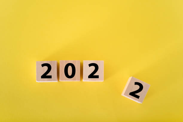 istock Wooden cubes on a yellow background and 2022. 1353742509