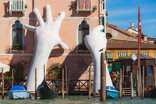 Venice, Italy - October - 07 October, 2017 Gigantic sculpture called Support for the Biennale 2017. Author - Lorenzo Quinn. The composition is dedicated to global warming