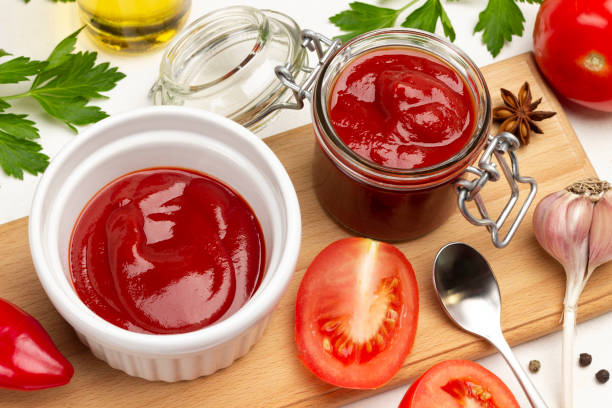 istock Tomato sauce, tomatoes and garlic on cutting board. 1353747275