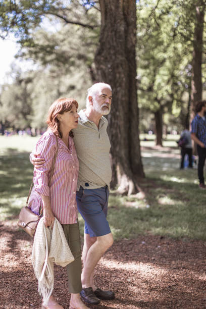 istock Senior couple in pleasant walk in the park 1353752829